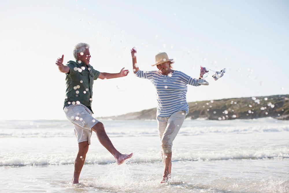 Zwei ältere Personen haben Spaß am Strand. 