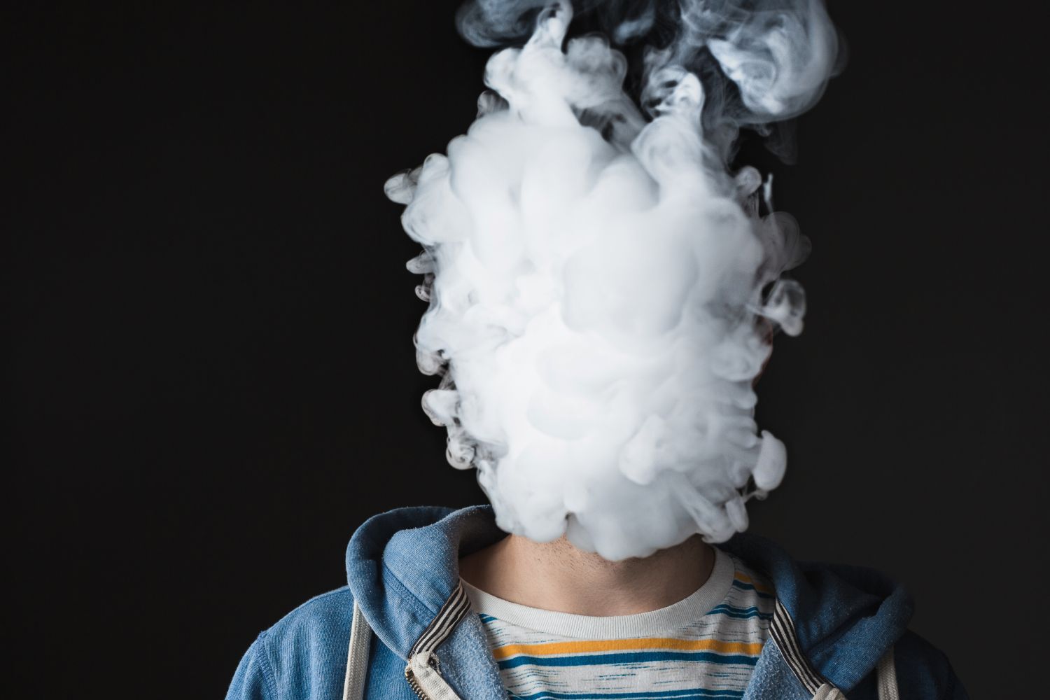 Ein Mensch atmet Zigarettenrauch aus. Thema: Lungenkrebs-Symptome