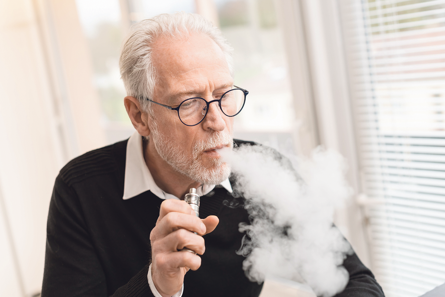 Ein älterer Mann raucht eine E-Zigarette.