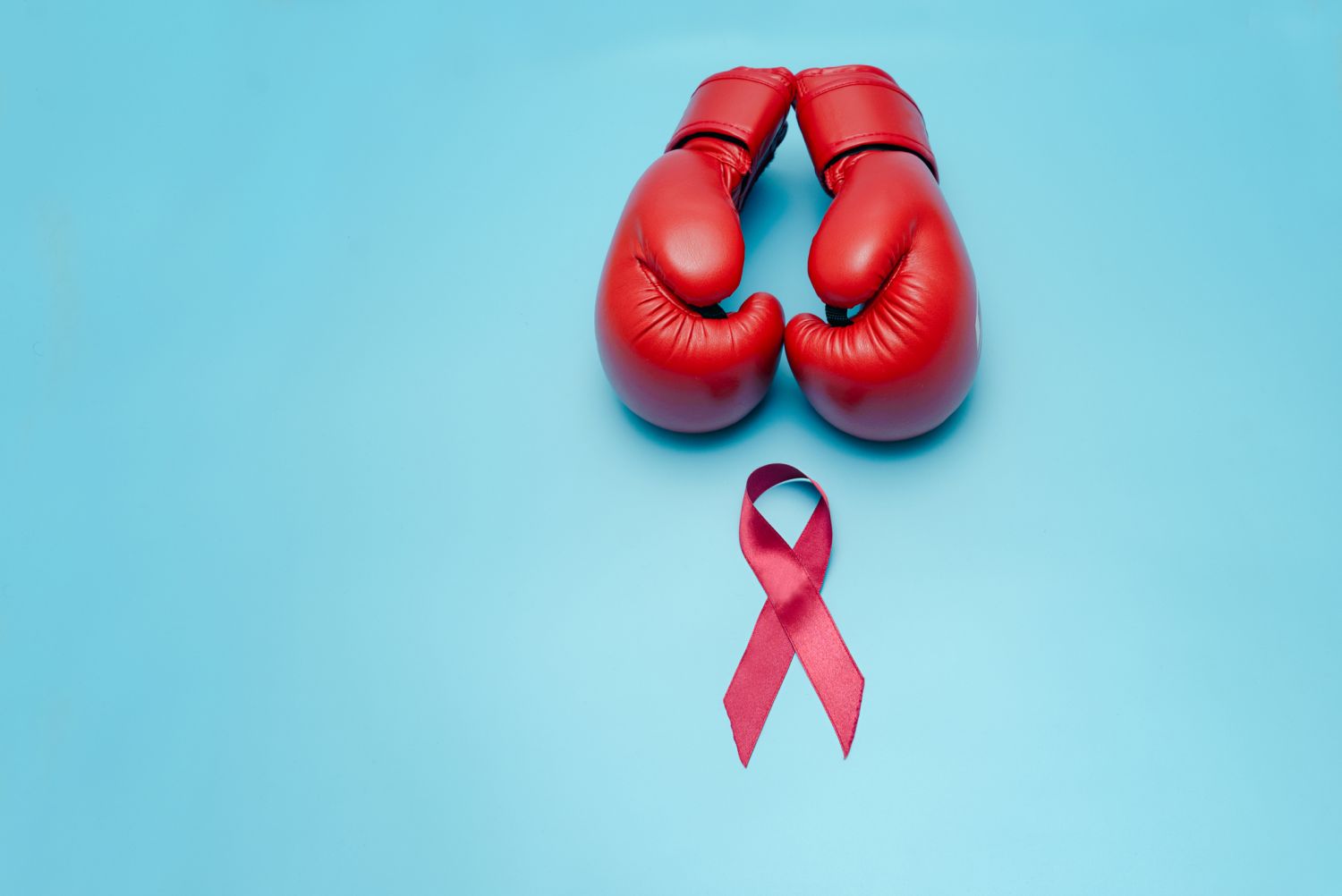 Rote Boxhandschuhe und rote AIDS Schleife als Zeichen für den Kampf gegen AIDS
