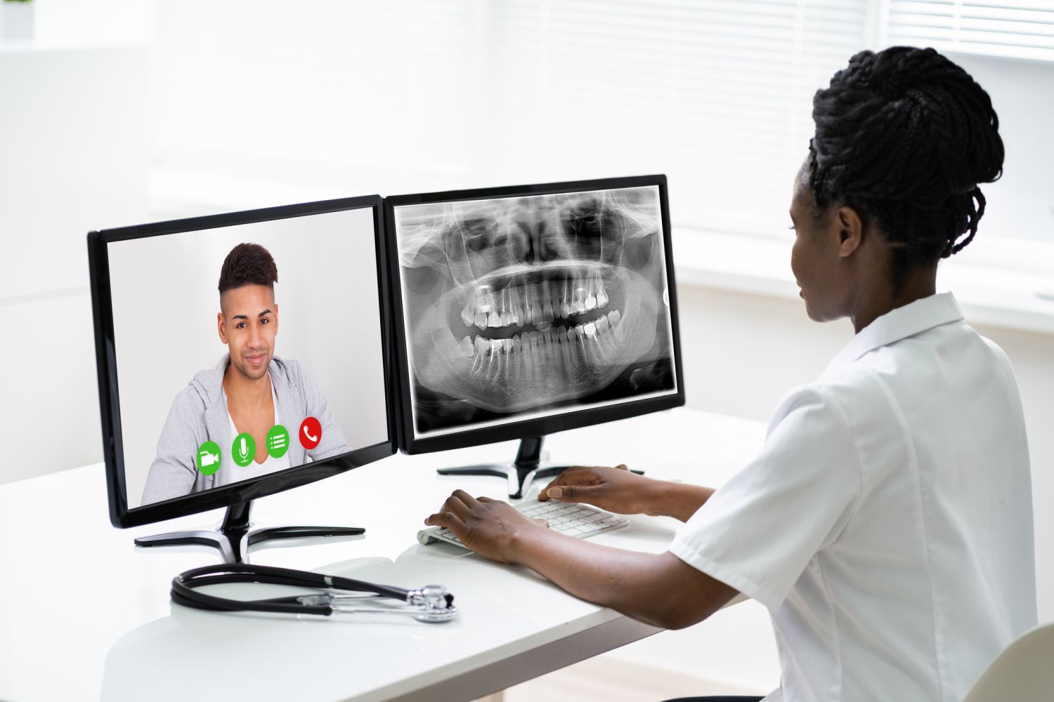 Zahnärztin führt mit einem Patienten eine Videosprechstunde