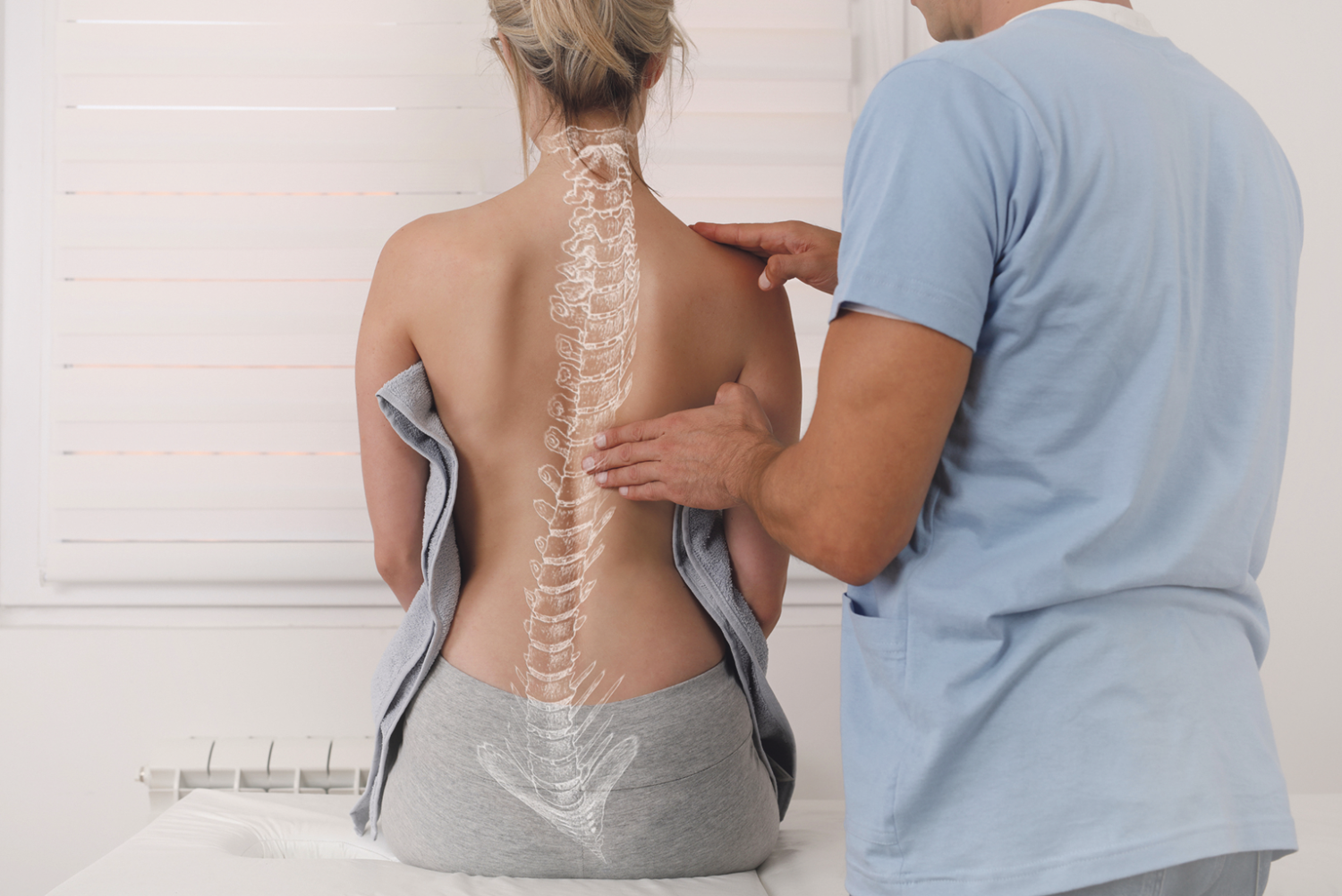 Eine Frau sitzt beim Arzt und lässt ihren Rücken untersuchen